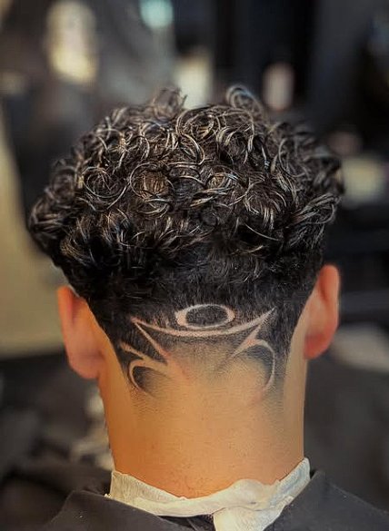 Cabelo cacheado com desenho feito na navalha na nuca